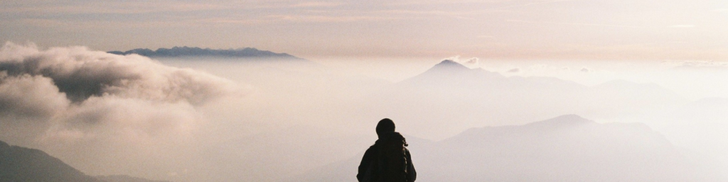 Man starting from the peak of the mountain the valley of clouds.